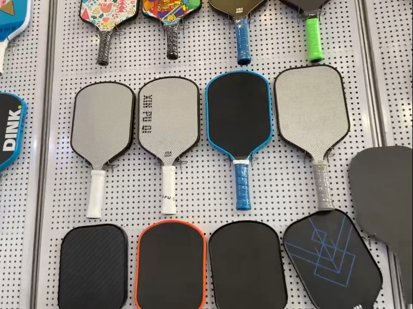 This wall is filled with a variety of Pickleball samples, including T700 Carbon fiber paddle,Fiberglass paddle,kevlar fiber paddle etc